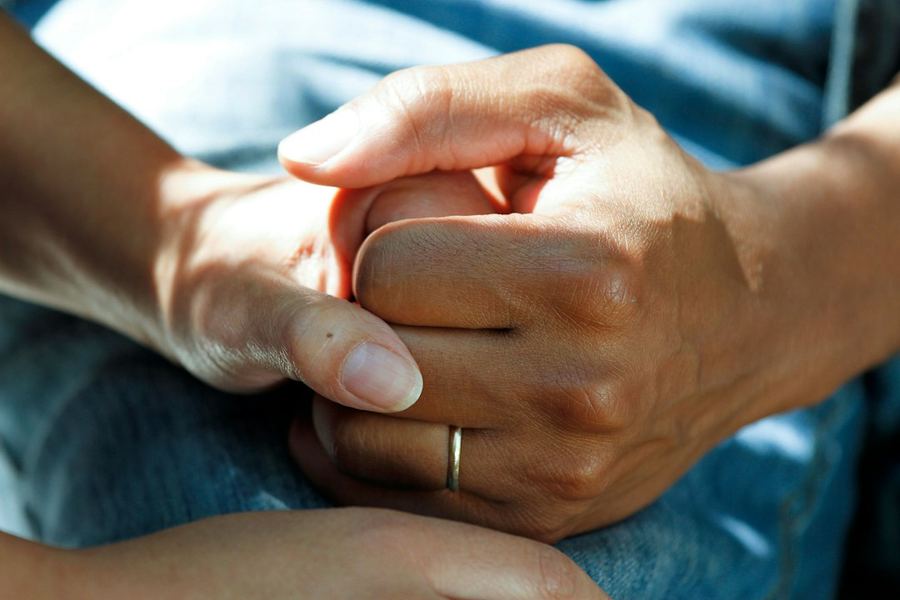 Eine Hand wird zur Unterstützung behutsam gehalten